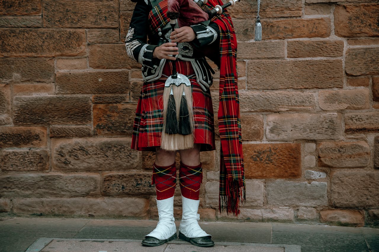 A man in full Scottish ceremonial attire, wearing a Kilt and complete with a set of bagpipes